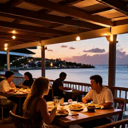 Caribbean Holidays, Active Caribbean Holidays, A relaxed open-air restaurant beside a Caribbean harbour at sunset, with local food, music and travellers enjoying the evening