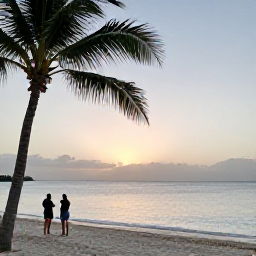 Caribbean Holidays, April Beach Holidays, A peaceful tropical beach in Turks and Caicos during April, with soft evening light, calm sea and a couple watching the sunset