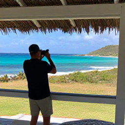 Caribbean Holidays, April Birdwatching, Friendly birdwatching guide and traveller observing birds from a shaded viewpoint overlooking Saint Barth&eacute;lemy coastline