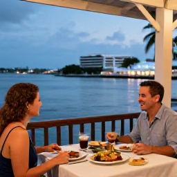 Caribbean Holidays, April Couples Holidays, Couple enjoying dinner at an open-air Caribbean restaurant in Charlotte Amalie, soft evening lighting, harbour views and local dishes