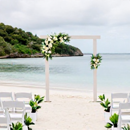 Caribbean Holidays, April Weddings, Elegant beach wedding ceremony in the British Virgin Islands with white chairs, simple tropical flowers and calm turquoise water