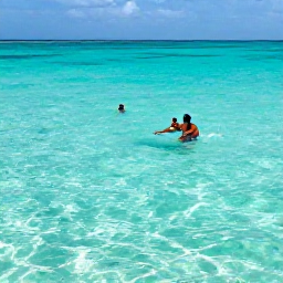 Caribbean Holidays, Aruba Beach Holidays, Visitors snorkelling in the shallow turquoise lagoon at Baby Beach, Aruba, with colourful fish and bright sunlight