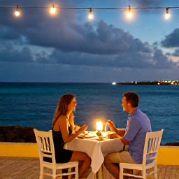 Caribbean Holidays, Aruba Couples Holidays, Romantic outdoor restaurant in Aruba with a couple dining beside the sea under warm evening lights