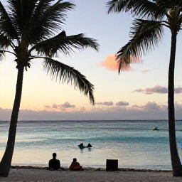 Caribbean Holidays, Aruba Diving April, A relaxed Aruba beach at sunset with palm trees, calm turquoise water and divers returning from a boat trip