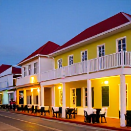 Caribbean Holidays, Aruba Honeymoons, Charming evening street in Oranjestad, Aruba, with colourful buildings, outdoor tables and warm Caribbean lights