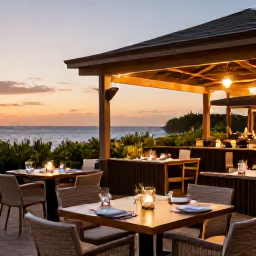 Caribbean Holidays, Aruba Luxury Holidays, A relaxed outdoor restaurant in Aruba serving fresh seafood at sunset, with stylish tables, tropical plants and warm evening lighting