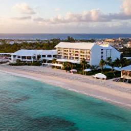 Caribbean Holidays, Aruba Luxury Holidays, Aerial view of Aruba&rsquo;s turquoise Caribbean coastline, white sandy beach, luxury resort and palm trees in warm morning light