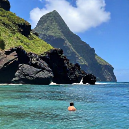 Caribbean Holidays, August Backpacking, Backpacker swimming in warm turquoise water beside Dominica's rugged volcanic coastline and green cliffs