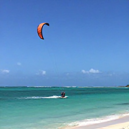 Caribbean Holidays, August Instagram Spots, Long Bay Beach in Providenciales, Turks and Caicos, with a kite surfer crossing bright turquoise water under a clear summer sky