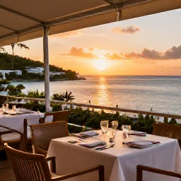 Caribbean Holidays, August Luxury Holidays, Fine dining restaurant terrace in Grand Case, Saint Martin, sunset over the sea, beautifully set table and relaxed elegant atmosphere