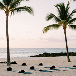 Caribbean Holidays, Bahamas Wellness Retreats, Outdoor yoga session on a quiet Bahamian beach, mats facing the sea, palm trees and soft morning light