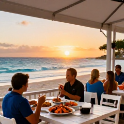 Caribbean Holidays, Barbados Beach Holidays, Outdoor beach restaurant in Barbados serving fresh seafood at sunset, with diners overlooking the Caribbean Sea