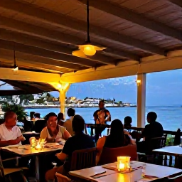 Caribbean Holidays, Barbados City Breaks, Relaxed evening in Bridgetown with diners at an outdoor restaurant, warm lights, live music and a glimpse of the Caribbean waterfront