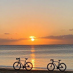Caribbean Holidays, Barbados Cycling October, Sunset over a Barbados beach with touring bicycles in the foreground, warm colours and calm Caribbean sea