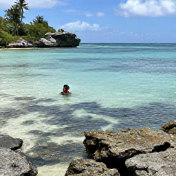 Caribbean Holidays, Barbados in March, A calm Barbados beach and rocky coastline in March, with clear shallow water, coral rocks and a snorkeller observing colourful fish