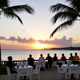 Caribbean Holidays, Barbados in October, Relaxed Barbados evening beside the sea, outdoor tables, gentle sunset light, local music and visitors enjoying an October holiday