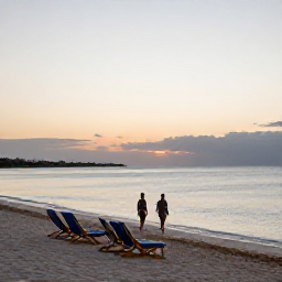 Caribbean Holidays, Bermuda Beach Holidays, A relaxed evening on a Bermuda beach with soft sunset light, calm sea, beach chairs and a couple walking along the shoreline