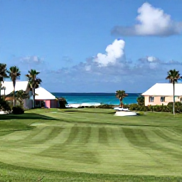Caribbean Holidays, Bermuda Golf Holidays, A scenic Bermuda golf course beside the Atlantic Ocean in bright July sunshine, with palm trees and pastel buildings