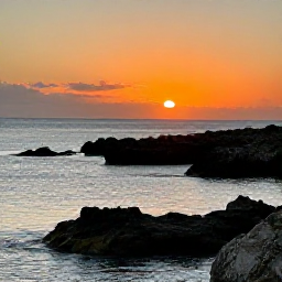 Caribbean Holidays, Bermuda Instagram Hotspots, A dramatic sunset over Bermuda's coastline in November, with dark rocks, calm sea and a warm orange sky