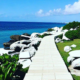 Caribbean Holidays, Bermuda Instagram Hotspots, Long white limestone steps and a rocky coastal path leading to blue ocean views at the Bermuda Railway Trail in August sunshine