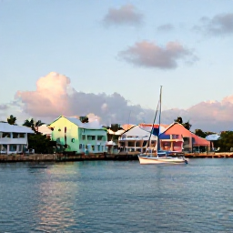 Caribbean Holidays, Bermuda Nature Holidays, A peaceful Bermuda harbour at sunset with a small sailing boat, pastel buildings, palm trees and calm blue water