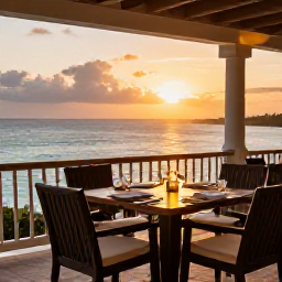 Caribbean Holidays, Bermuda Spa Breaks, Elegant Bermuda restaurant terrace at sunset, table set for dinner with ocean views and soft warm lighting