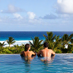 Caribbean Holidays, Caribbean December, Couple relaxing beside an infinity pool overlooking a tropical Caribbean coastline