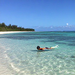 Caribbean Holidays, Caribbean Snorkelling, Quiet Caribbean beach with a visitor snorkelling in shallow transparent water beside a sheltered reef