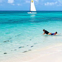Caribbean Holidays, Caribbean Sporting Holidays, Travellers snorkelling and sailing in clear Caribbean water near a white sandy beach, colourful fish visible below the surface