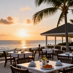 Caribbean Holidays, Cayman Beach Holidays, A relaxed beachfront restaurant at sunset on Grand Cayman, with outdoor tables, seafood dishes and palm trees