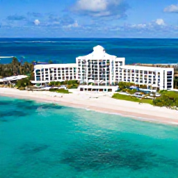 Caribbean Holidays, Cayman Islands All Inclusive, A bright aerial view of Grand Cayman&rsquo;s turquoise sea, white sandy beach and relaxed beachfront resort in June sunshine