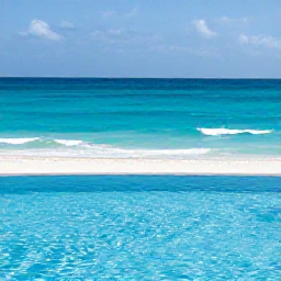 Caribbean Holidays, Cayman Islands July, Peaceful adults-only resort pool overlooking a white sandy beach and clear Caribbean water in Grand Cayman