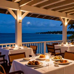 Caribbean Holidays, Cayman Luxury Holidays, Elegant open-air restaurant overlooking the Caribbean sea on Grand Cayman, beautifully presented local seafood and warm evening lighting