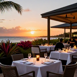 Caribbean Holidays, Cayman Luxury May, Sophisticated outdoor restaurant in Grand Cayman at sunset, with beautifully set tables, tropical plants and diners enjoying Caribbean cuisine