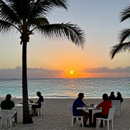 Caribbean Holidays, Cheap Aruba March, Aruba sunset over a quiet beach with palm trees, casual outdoor dining and travellers enjoying an affordable evening