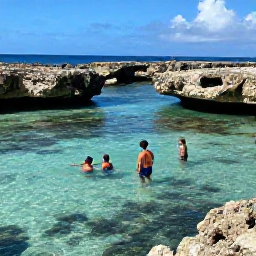 Caribbean Holidays, Cheap August Aruba, Snorkellers exploring clear shallow water near Aruba&rsquo;s coast, with colourful fish and rocky coral surroundings