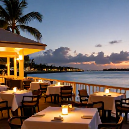 Caribbean Holidays, Cheap Cayman Holidays, A relaxed evening at a waterfront restaurant in Grand Cayman, with outdoor tables, warm lights and a Caribbean sunset