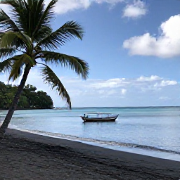 Caribbean Holidays, Cheap Dominica Holidays, A quiet black sand beach on Dominica with palm trees, calm turquoise water and a simple local fishing boat