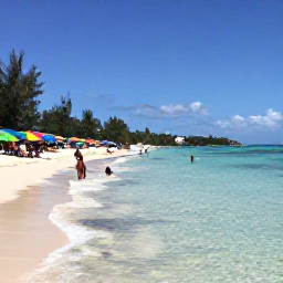 Caribbean Holidays, Cheap May Holidays, Travellers enjoying a calm Antiguan beach with clear shallow water, colourful umbrellas and a relaxed local atmosphere
