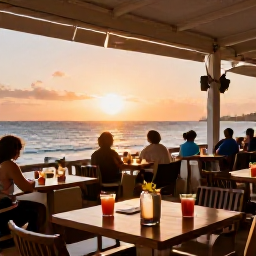 Caribbean Holidays, Curacao Beach Holidays, Relaxed beachfront restaurant in Curacao at sunset, with outdoor tables, tropical drinks and diners enjoying the view