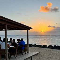Caribbean Holidays, Cura&ccedil;ao Business Class, Sunset over Cura&ccedil;ao coastline with a small restaurant terrace and travellers enjoying dinner outdoors
