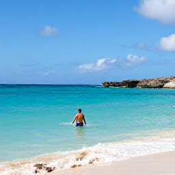 Caribbean Holidays, Curacao City Breaks, Traveller swimming in clear turquoise water at a sandy Curacao beach, with rocky coastline and bright blue sky