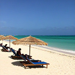 Caribbean Holidays, Cura&ccedil;ao in April, Quiet Cura&ccedil;ao beach with clear turquoise water, shaded sun loungers and visitors enjoying a warm April day