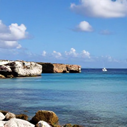 Caribbean Holidays, Cura&ccedil;ao in April, Sunny Cura&ccedil;ao coastline in April with calm turquoise water, rocky coves and a small sailing boat