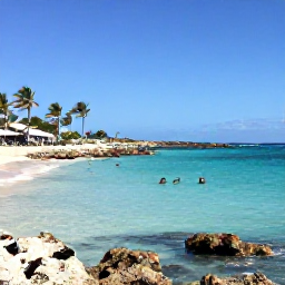 Caribbean Holidays, Cura&ccedil;ao in October, Clear turquoise sea at a secluded Cura&ccedil;ao beach with snorkellers, rocky coastline, palm trees and bright October sunshine