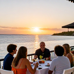 Caribbean Holidays, February Family Holidays, Family enjoying an outdoor dinner at a relaxed waterfront restaurant in The Bahamas at sunset