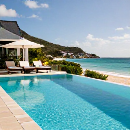 Caribbean Holidays, February Holidays, Adults relaxing beside a stylish beachfront pool on Saint Barth&eacute;lemy in warm February sunshine