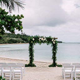 Caribbean Holidays, February Weddings, An elegant outdoor wedding ceremony on a tranquil Montserrat beach, with simple white chairs, tropical greenery and calm turquoise water