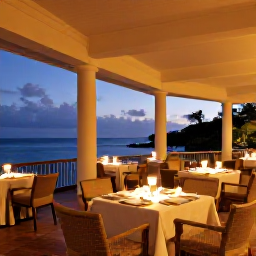 Caribbean Holidays, Grenada Adults Only, Elegant adults-only Caribbean resort terrace at evening, with dinner tables, warm lighting and views across the sea