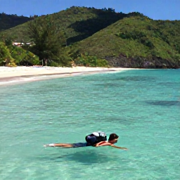 Caribbean Holidays, Grenada Backpacking, A backpacker swimming in clear water at Grand Anse Beach, Grenada, with a wide crescent of sand and green hills